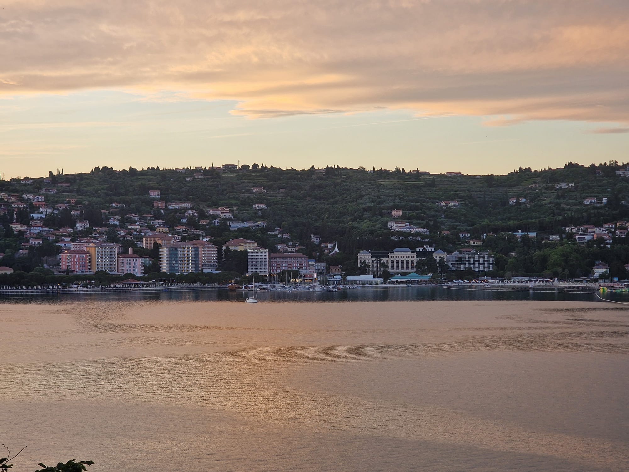 Portorož bay at dusk with hotels and resort buildings along the waterfront